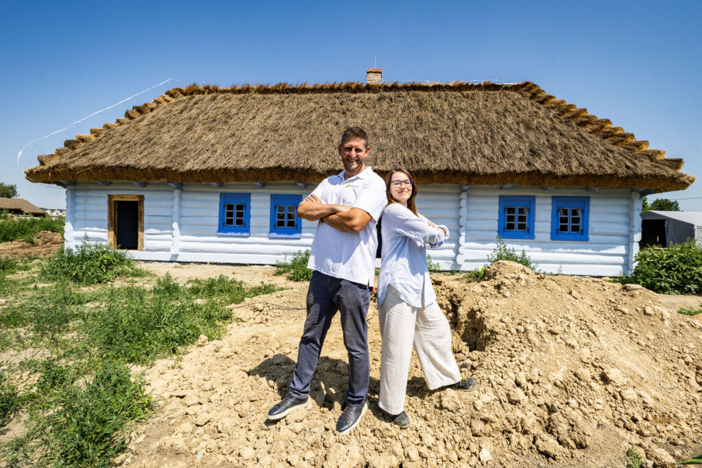 Zdjęcie przedstawia Marcina Rybskiego i Annę Wózek na tle Chałupy z ul. Nadbrzezie 24